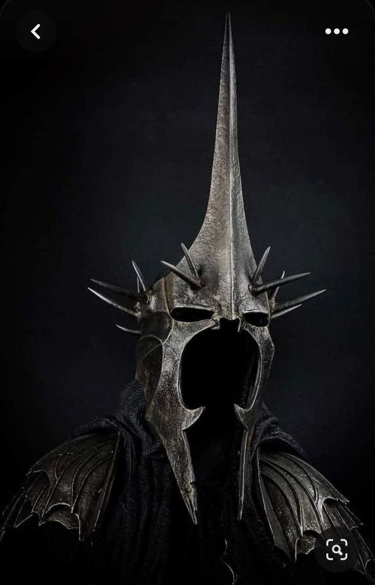 a man wearing a helmet with spikes on it's head and horns sticking out from his mouth