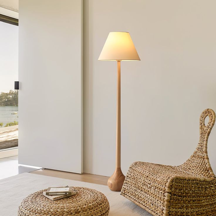 a living room with wicker furniture and a lamp on the floor next to it