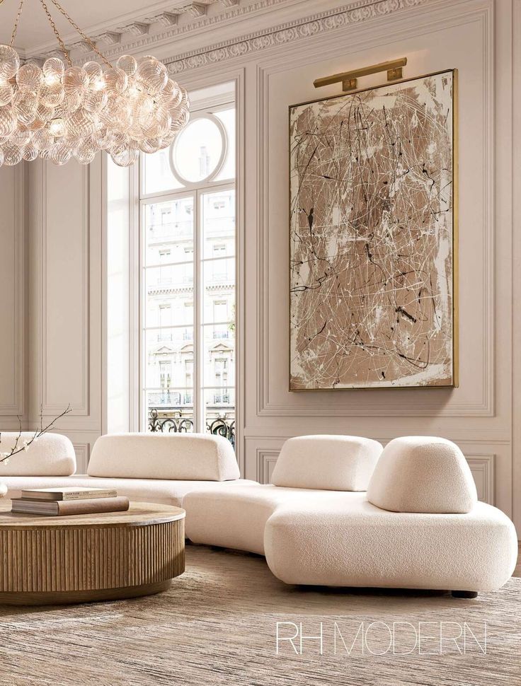 a living room filled with white furniture and a chandelier hanging from the ceiling