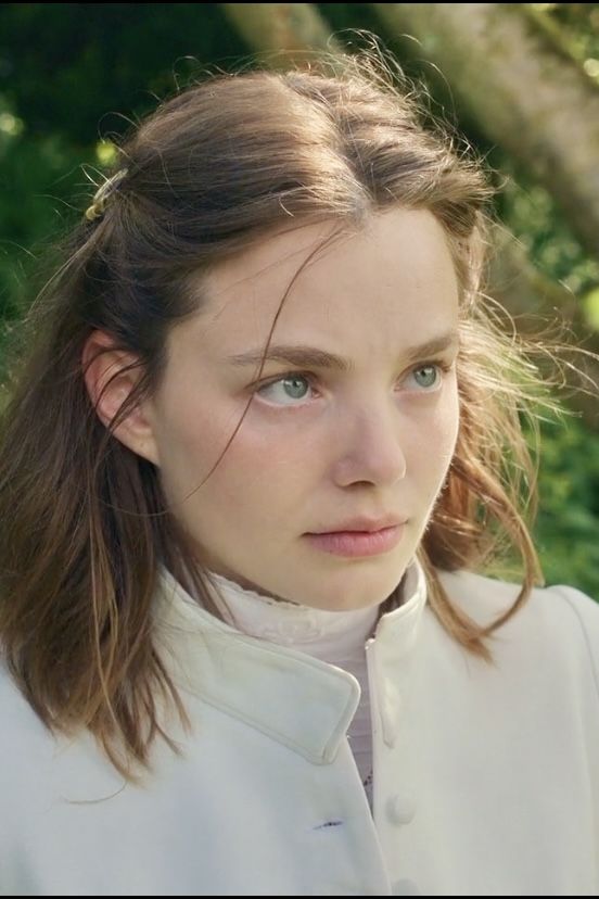 a close up of a person wearing a white shirt and looking off to the side