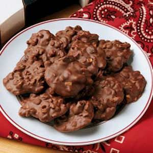 a white plate topped with chocolate cookies on top of a red table cloth next to a bottle