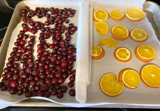 oranges and cranberries are arranged on trays to be decorated with icing