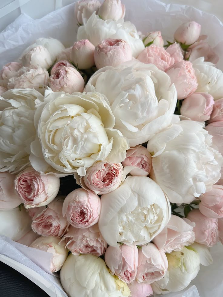 a bouquet of white and pink peonies