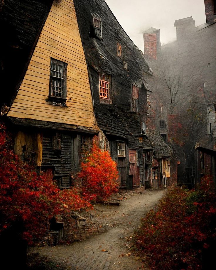 an old wooden house with red leaves on the ground and fog in the air behind it