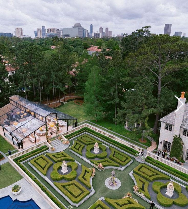 an aerial view of a formal garden in the middle of a park with lots of trees