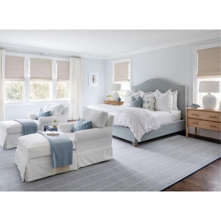 a bedroom with blue walls and white furniture