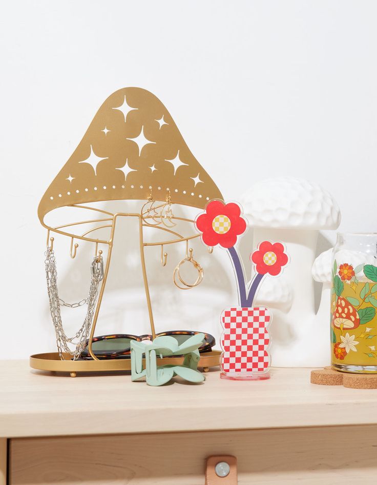 a wooden table topped with vases filled with flowers next to a metal object on top of a shelf