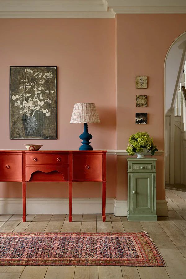 a living room with pink walls and furniture