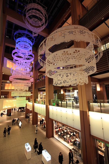 an overhead view of people walking through a shopping mall with chandeliers hanging from the ceiling