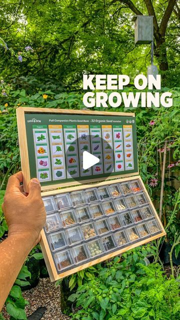 a person holding up a poster in front of some plants and trees with the words keep on growing