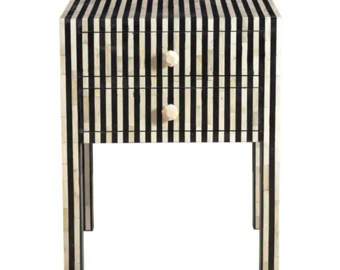 a black and white striped side table with drawers