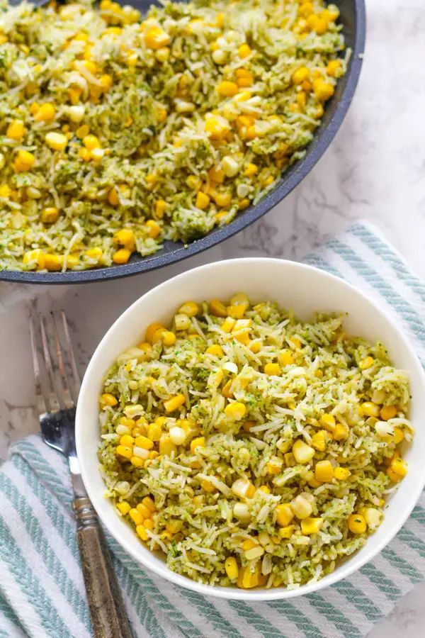 a bowl filled with rice and corn on top of a table