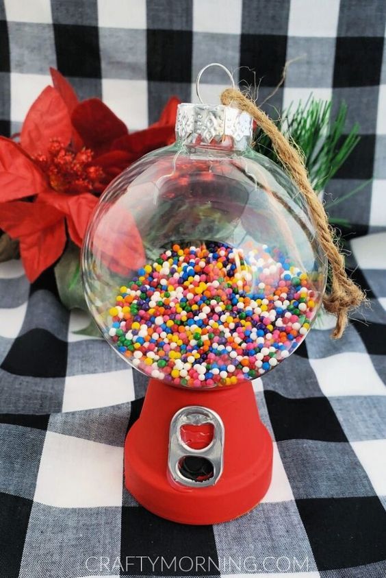 a christmas ornament filled with sprinkles on top of a checkered table cloth