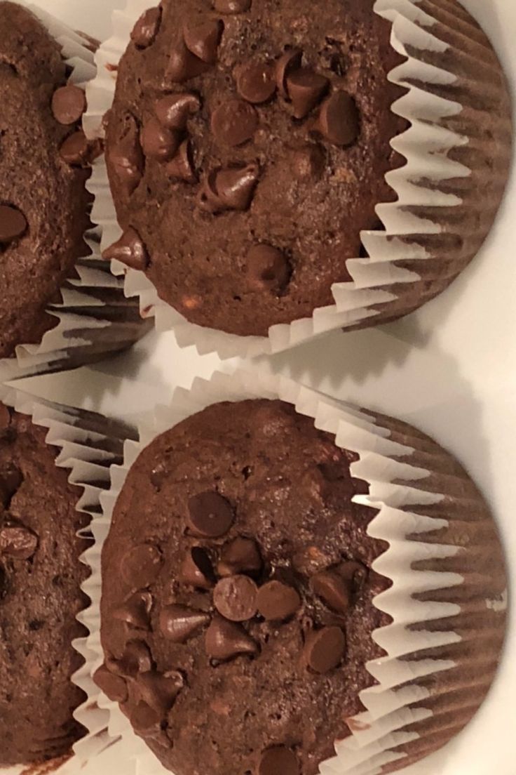 four chocolate muffins sitting on top of each other