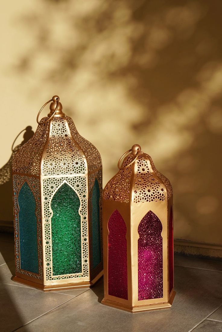 two colorful lanterns sitting on top of a tile floor