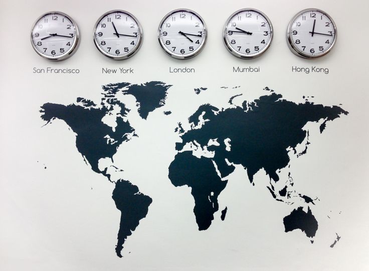 a wall with clocks and the world map on it