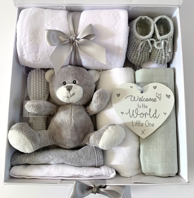 a baby gift box with a teddy bear, mittens, blanket and booties