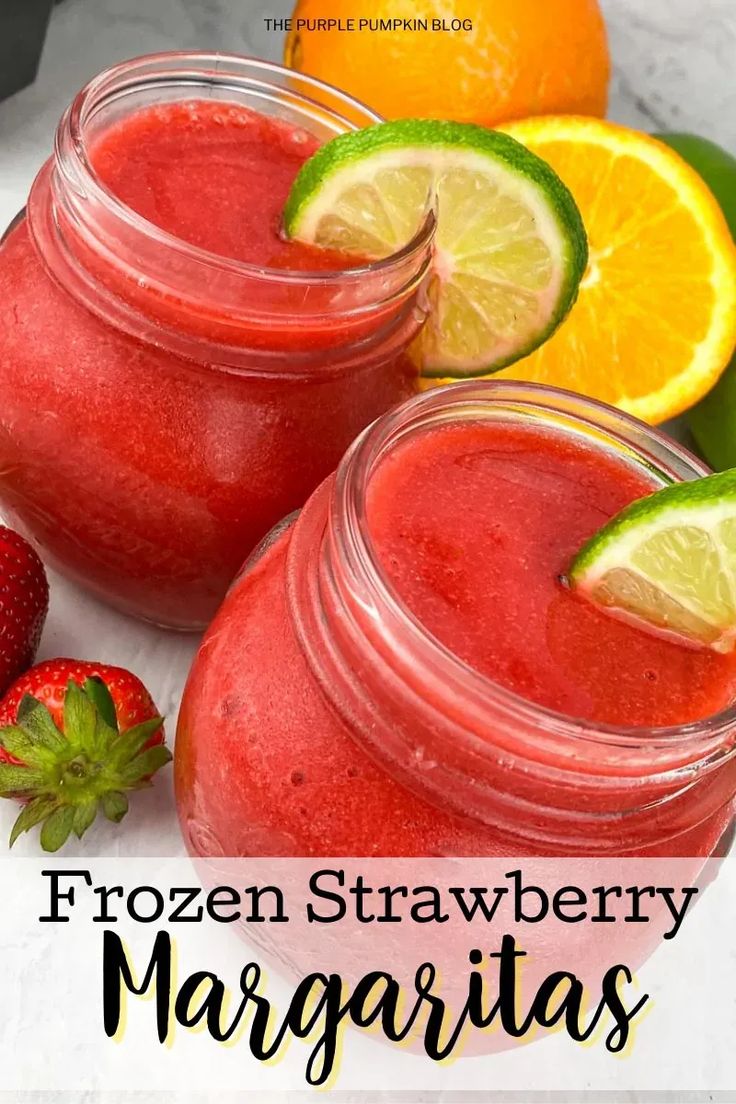 two mason jars filled with frozen strawberry margaritas next to strawberries and lemons