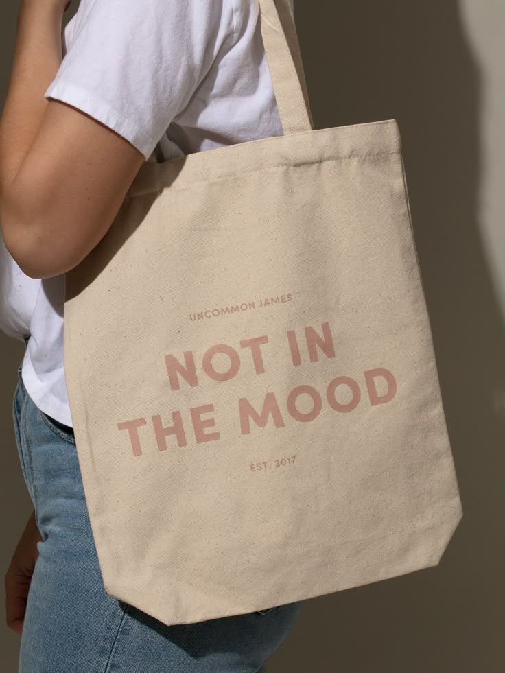 Our Not In The Mood Canvas Tote Bag is the ultimate accessory for when you’re going out but don’t actually want to deal with anyone. Want more Uncommon James merch and tote bags? Shop all of our apparel and accessories. Everyday Tote Bags With Graphic Print, Daily Use Tote Bag With Branding, Tote Bag Cricut Ideas, Tote Bag Product Photography, Everyday Canvas Tote Bag With Graphic Print, Trendy Graphic Print Canvas Tote Bag, Everyday Graphic Print Tote Bag, Unique Merch, Tote Bag Accessories