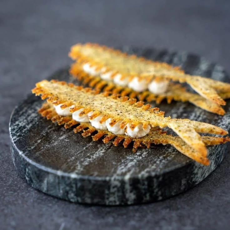 two pieces of fried food on a black plate