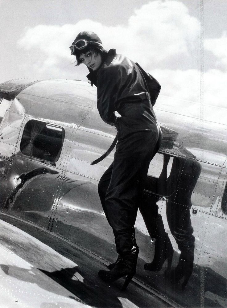 an old photo of a woman standing on the wing of a plane