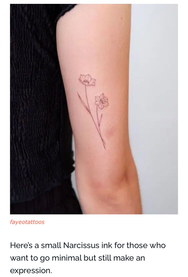 a small flower tattoo on the left upper arm and lower arm, with text below it