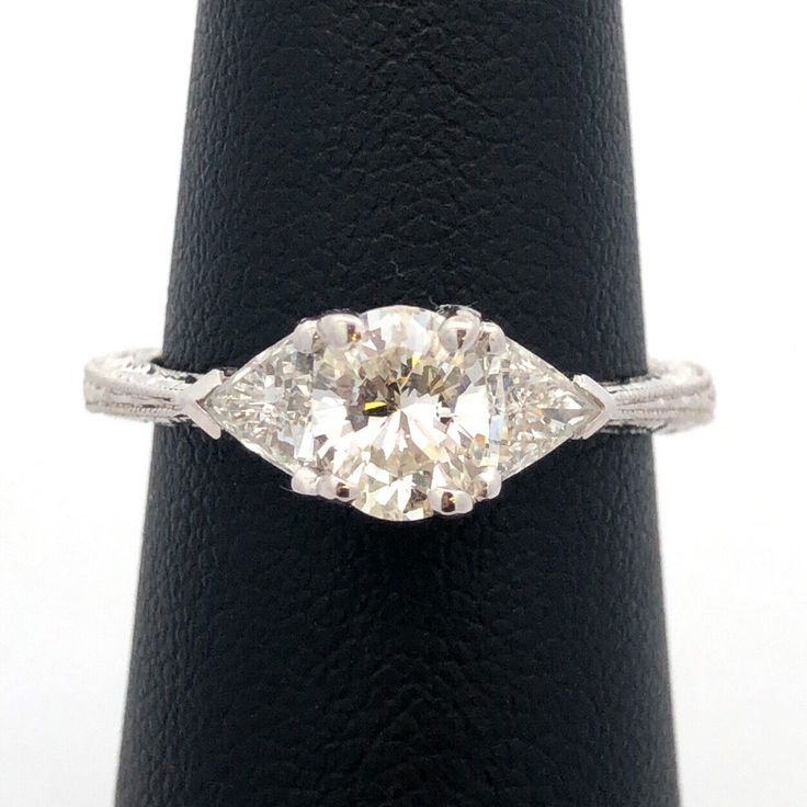 an old cut diamond ring with two pear shaped diamonds