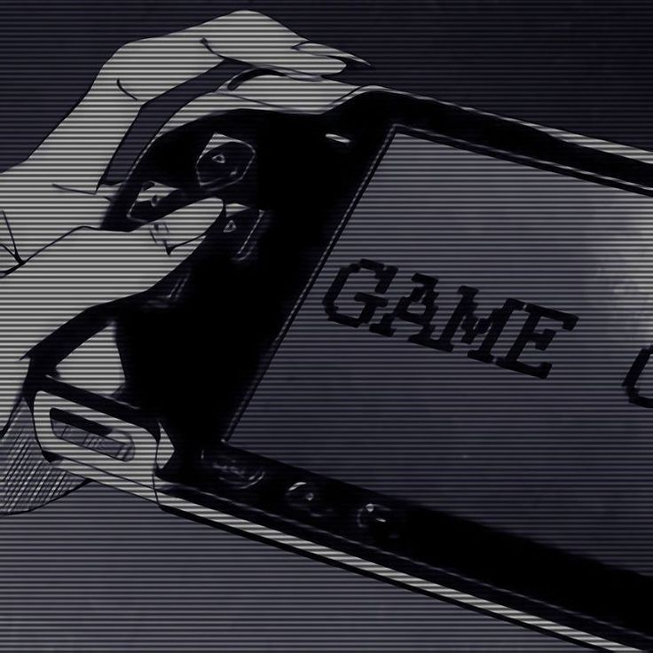 a hand holding a game controller in front of a screen with the word game on it