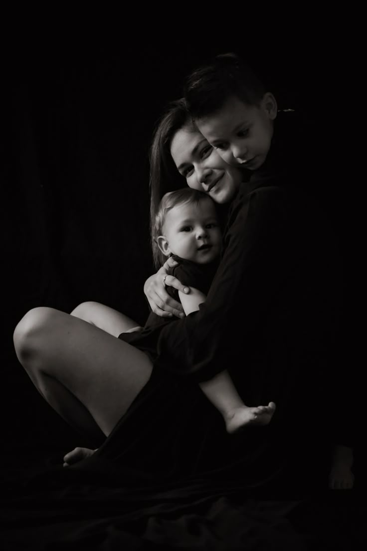 two women and a baby are posing for a black and white photo with their arms around each other