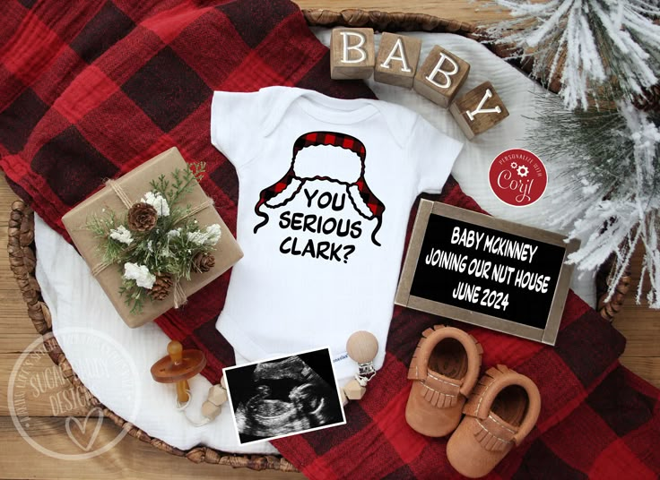 a baby's bodysuit and other items are laid out on a plaid blanket