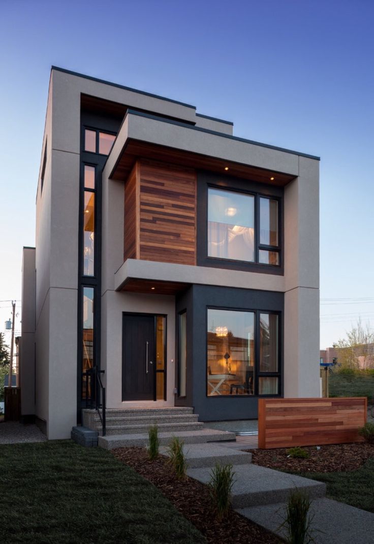 a modern house with wood and glass on the front door, stairs leading up to it