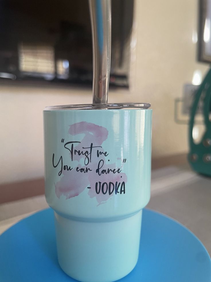 a cup with a straw sticking out of it sitting on top of a blue plate