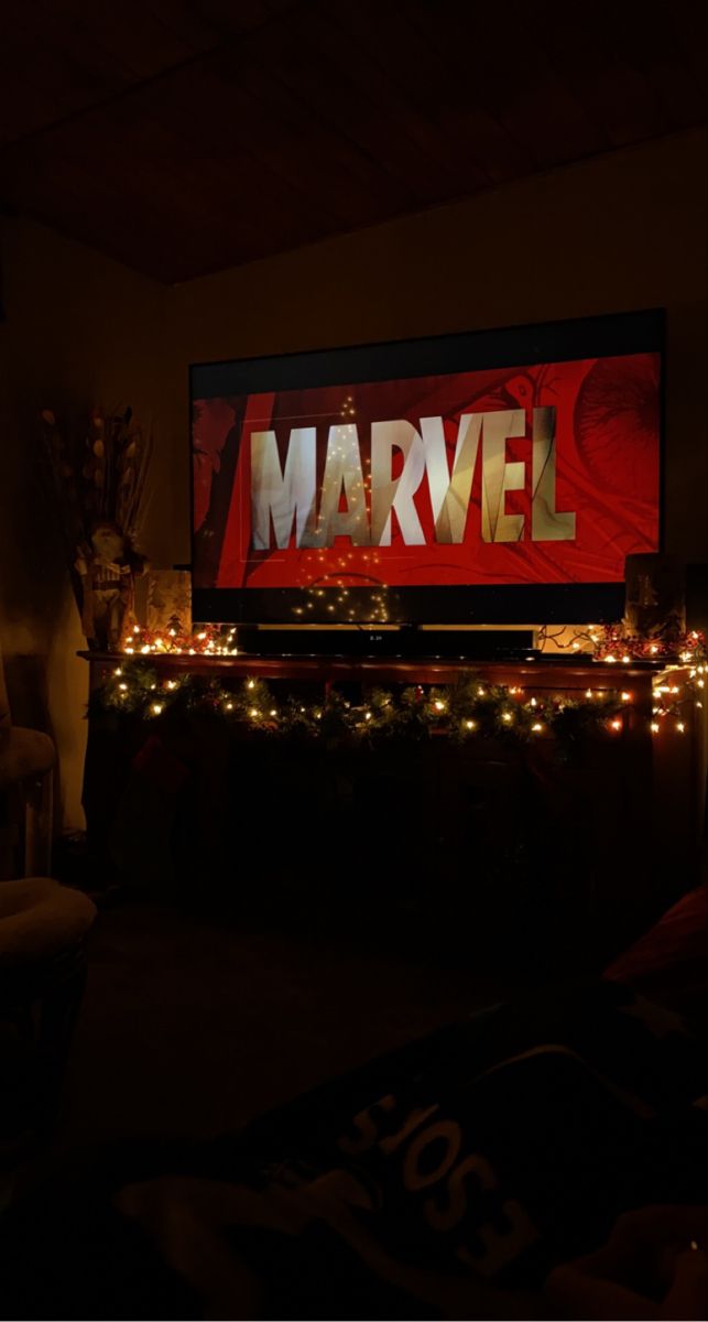 a large television screen with the word marvel on it in front of some christmas lights