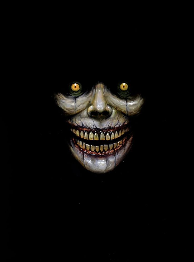 an evil looking clown with yellow eyes and fangs on it's face in the dark