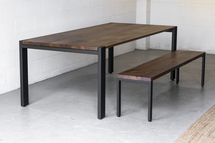 two wooden benches sitting next to each other in a room with white walls and cement flooring