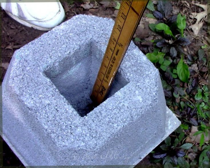 there is a measuring tape sticking out of a cement block that has been placed in the ground