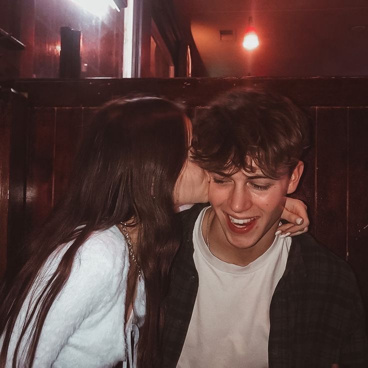 a man and woman kissing each other in a restaurant