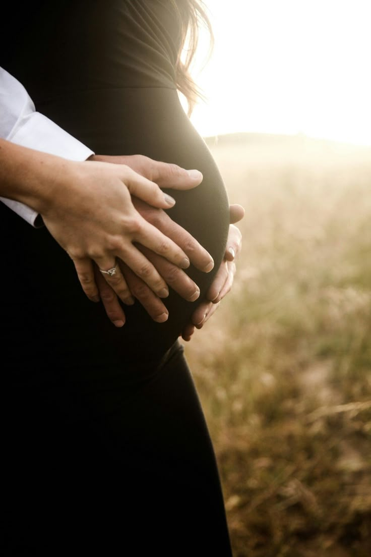 a pregnant woman holding her husband's belly