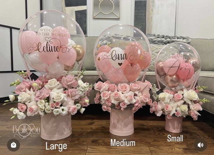 three vases filled with pink and white flowers sitting on top of a wooden table