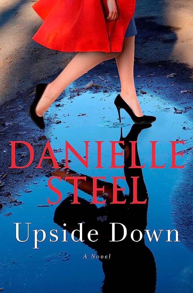 the cover of upside down by danielle steel, which features a reflection of a woman in a puddle