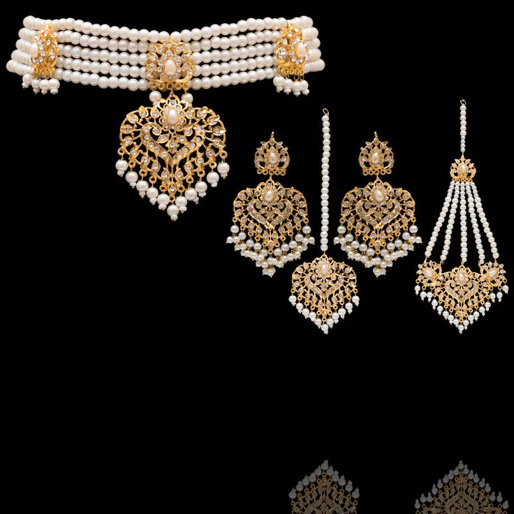 Elevate your ensemble with this resplendent set and create a grandeur and graceful look! A lustrous pearl ensemble that is a testament to enduring beauty creates a cascade of sophistication with CZ stones. The set includes a choker, a maang teekah, a jhoomar/passa and a pair of earrings. Gold-plated on high-quality brass as base metal. Made by order. Kindly allow 5-7 weeks for the delivery of this item. For custom or urgent requests, please contact support@alacouture.com. *Please Note: We use fa Elegant Kundan Sets For Ceremonial Occasions, Elegant Bridal Necklace For Eid Ceremony, Elegant Ceremonial Bridal Necklace For Eid, Elegant White Pearl Sets, Elegant Heavy Bridal Necklace For Eid, Elegant White Tilla Sets, Elegant White Sets With Tilla Detailing, Festive Wedding Pearl Sets, Bollywood Style Pearl Sets With Stone Work