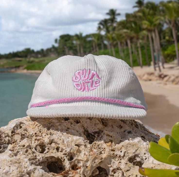 The White and Light Pink Corduroy SunDaze Circle 5-panel hat beautifully captures the essence of the 80's surf era, effortlessly merging classic design elements with a contemporary twist. Crafted from premium white and gentle light pink corduroy fabric, this cap presents a distinct circular emblem adorning its front panel, paying a heartfelt homage to the iconic sun-soaked days of 1980s surf culture. The delicate hues of white and light pink corduroy conjure images reminiscent of the enchanting sunsets over the California coast. This color scheme not only evokes the ethereal beauty of those picturesque sunsets but also reverently nods to the nostalgia-infused vibes that define the era it draws inspiration from. With a 5-panel construction, the cap ensures a comfortable and secure fit, acco Surf Hats, Corduroy Hat, Flat Hats, 5 Panel Hat, Pink Corduroy, Vintage Sunset, Surf Culture, Panel Hat, California Coast