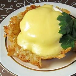 a plate topped with an open face sandwich covered in mayonnaise and garnished with parsley