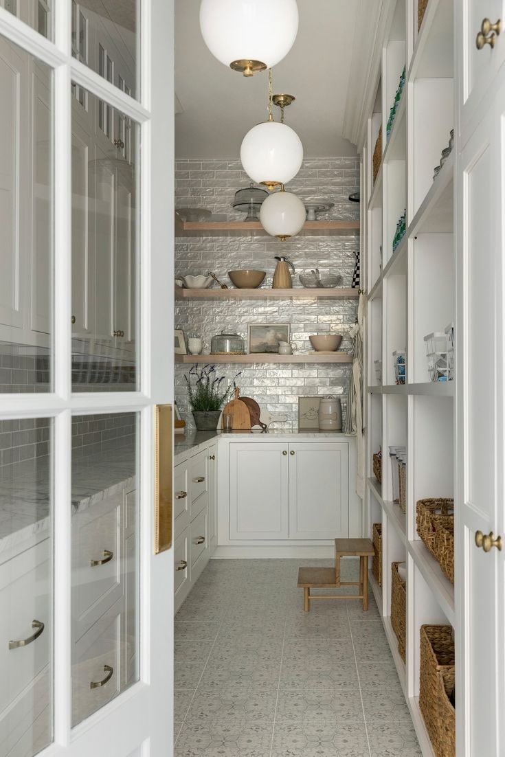 an open pantry with lots of white cupboards