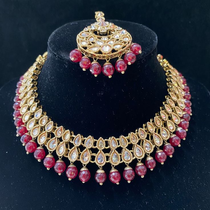 A Very Beautiful And Delicate Gold Polki Necklace With Maroon/Red Beads. This Set Includes A Matching Pair Of Earring And A Tikka. Festive Round Beaded Jewelry Sets, Elegant Jewelry Sets With Dangling Beads For Celebration, Festive Red Elegant Pearl Necklace, Festive Beaded Kundan Necklace, Kundan Jewelry With Polished Beads For Party, Elegant Kundan Necklace With Dangling Beads For Wedding, Elegant Festive Jewelry Sets With Dangling Beads, Festive Elegant Jewelry Sets With Dangling Beads, Elegant Ruby Beaded Necklaces For Festive Occasions