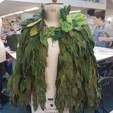 a mannequin is covered in fake leaves