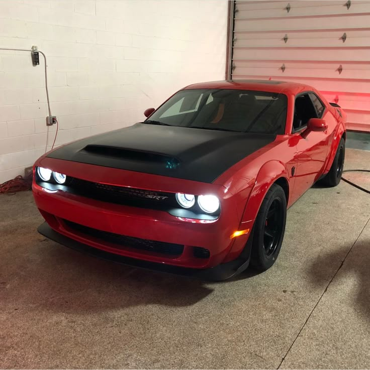 a red and black car parked in a garage