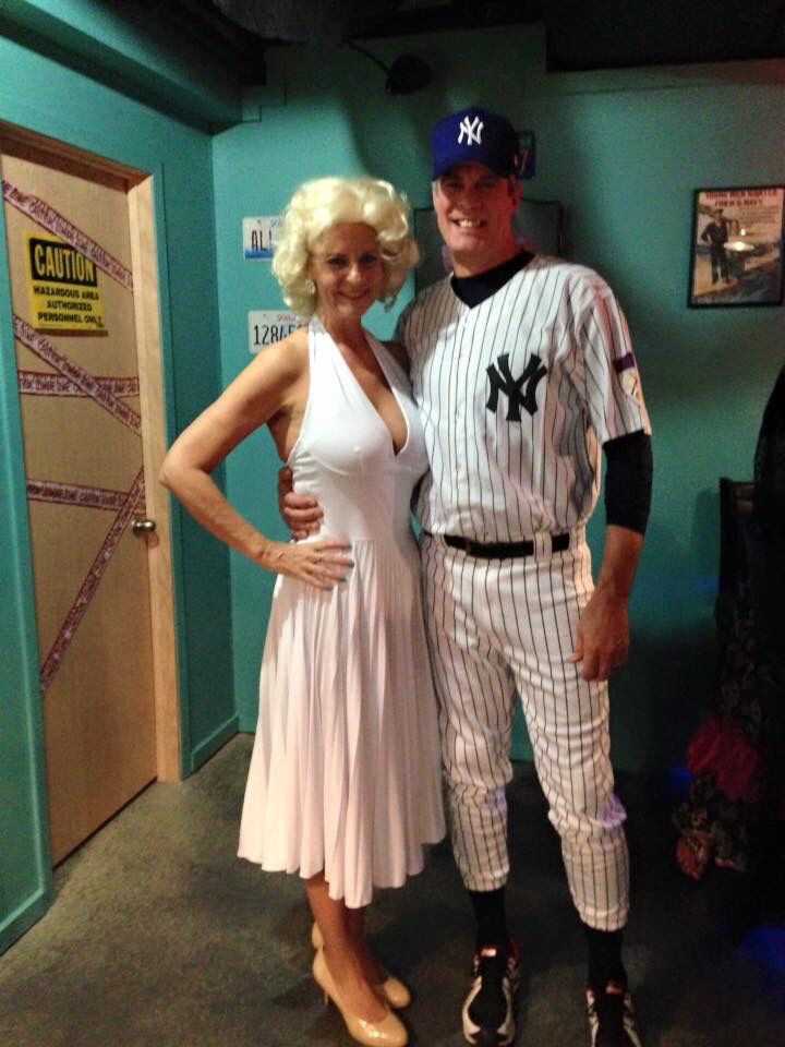 a man and woman dressed up in baseball uniforms