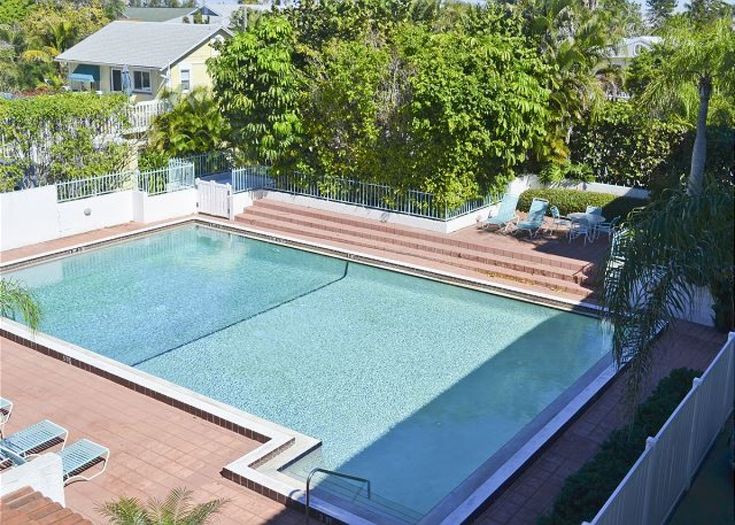 an aerial view of a swimming pool surrounded by trees