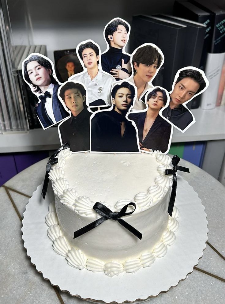 the cake is decorated with pictures of people on it and has black ribbon around the edges